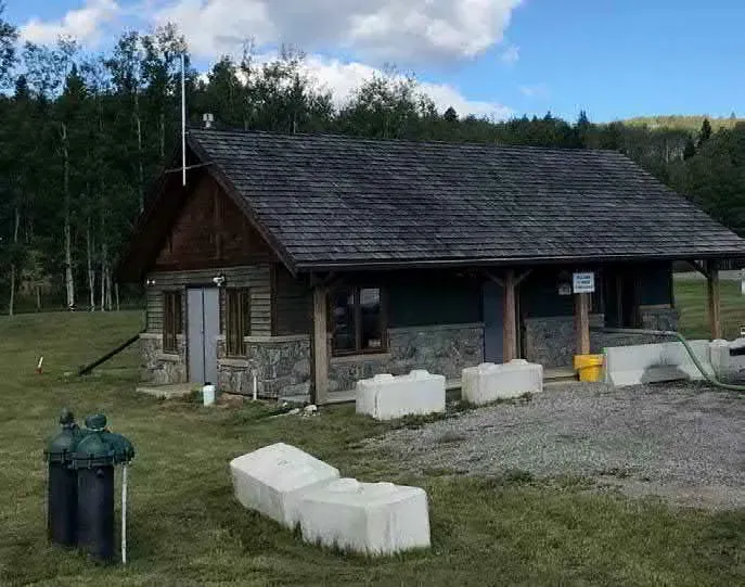 The treatment plant. The building was finished in wood and stone so that it reads as a house from the highway. Associated Engineering Alberta Ltd., 2018.